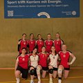 Weibliches Volleyballteam der TU Berlin bei der DHM Volleyball Vorrunde in Berlin vor einem blauen Stromnetz Berlin Banner