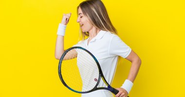 Frau in Siegerpose mit Tennisschläger