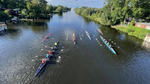 Mehrere Ruderboote mit Besatzung auf dem Wasser aus der Vogelperspektive