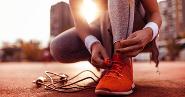 Sportlerin bindet sich die Schuhe zu