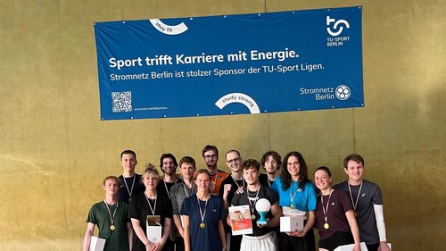 Volleyballteam vor einem Banner mit der Partnerschaft mit Stromnetz Berlin aufgedruckt