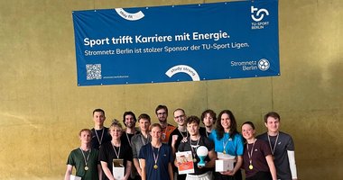 Volleyballteam vor einem Banner mit der Partnerschaft mit Stromnetz Berlin aufgedruckt