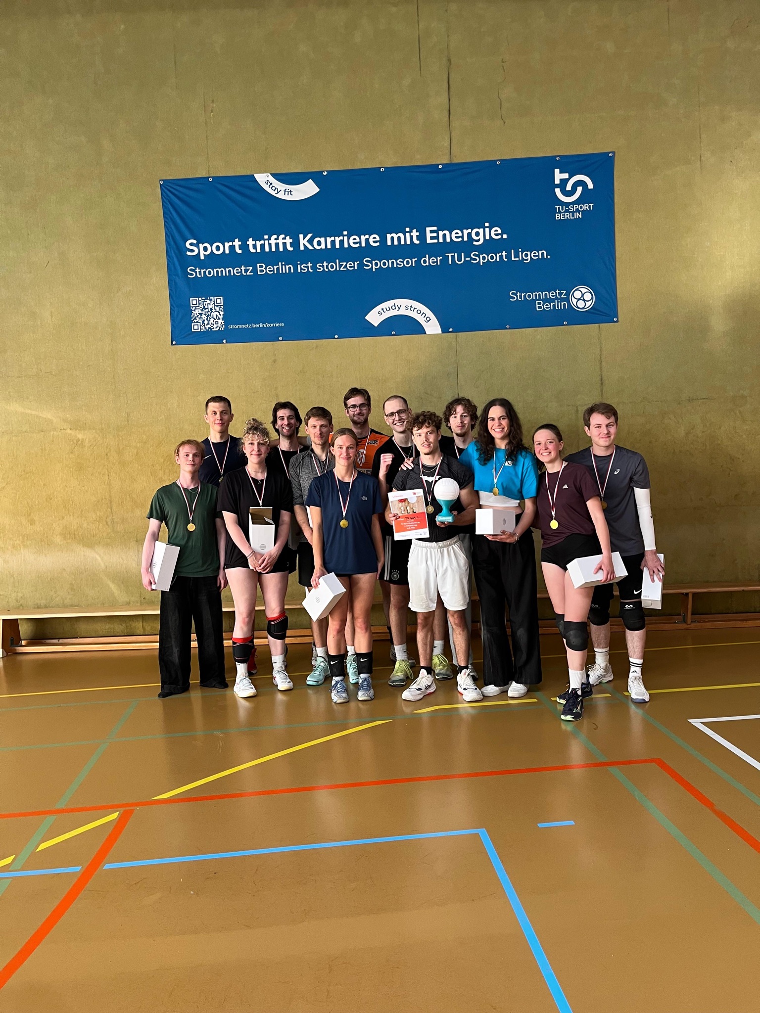 Volleyballteam vor einem Banner mit der Partnerschaft mit Stromnetz Berlin aufgedruckt